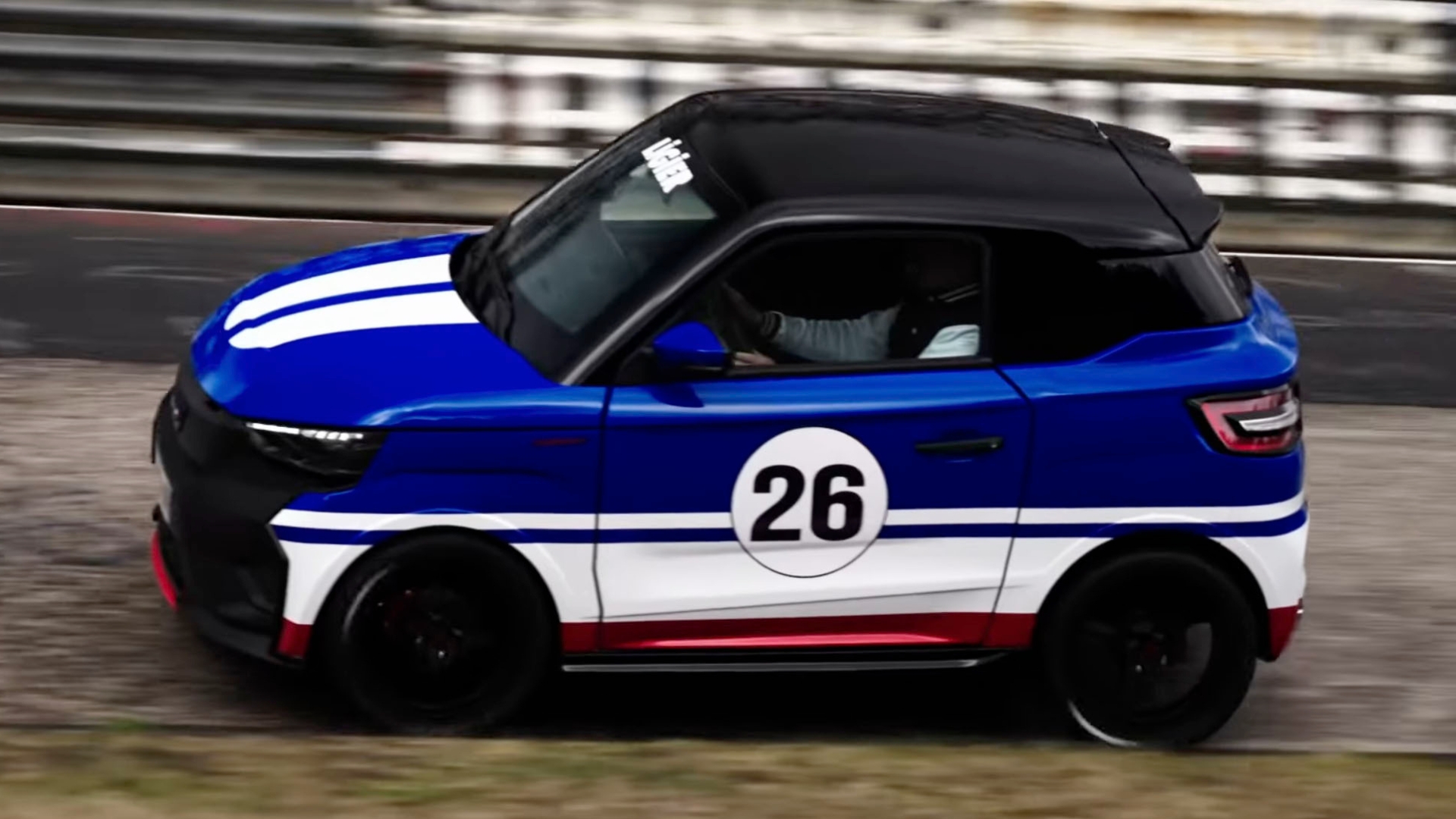 A blue and white car with the number 26 on the side races on a track.